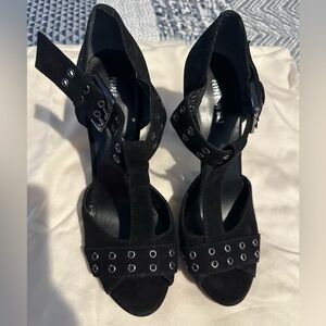Open toed black suede heels.